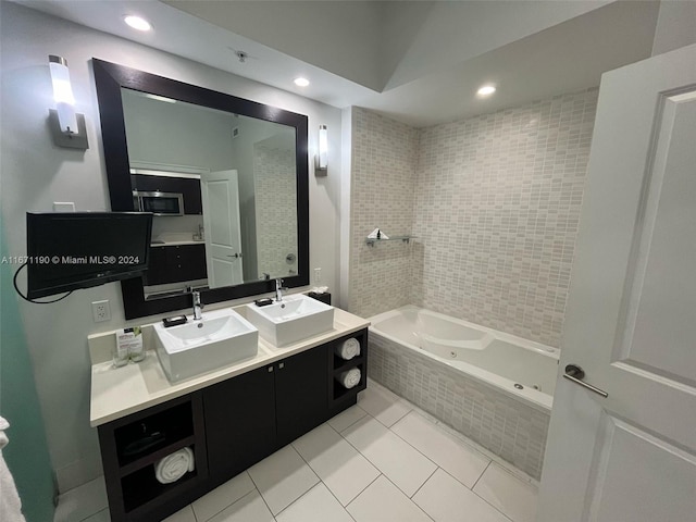 bathroom with tile patterned flooring, tiled bath, and vanity