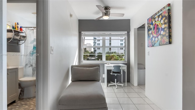 living area featuring ceiling fan, built in desk, and light tile patterned floors