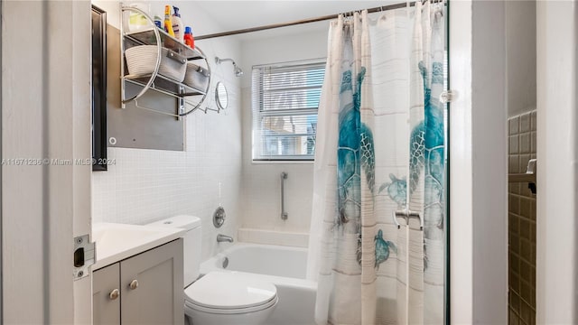 full bathroom with tile walls, vanity, toilet, and shower / bathtub combination with curtain