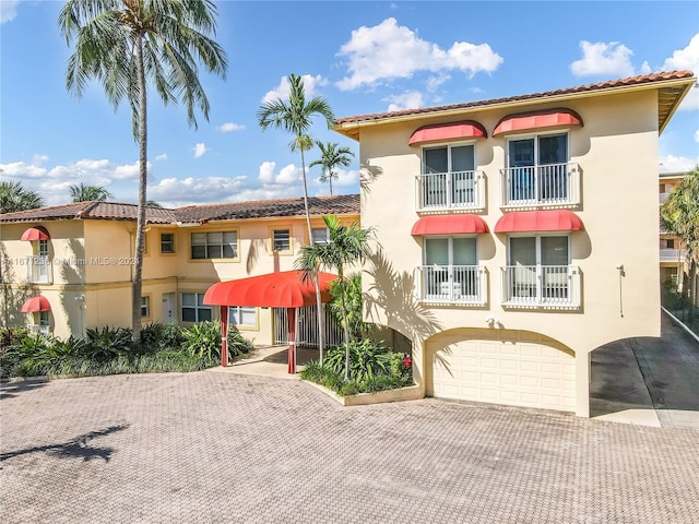 mediterranean / spanish-style home with a balcony and a garage