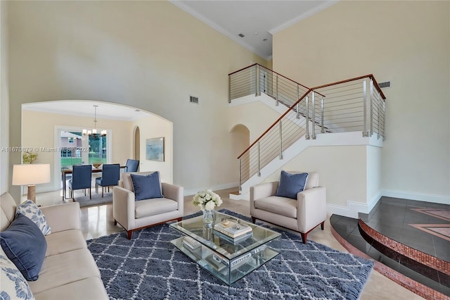 tiled living room with a towering ceiling, a notable chandelier, and crown molding