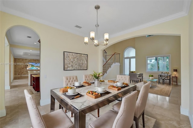 tiled dining room featuring an inviting chandelier and crown molding