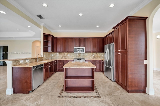 kitchen featuring sink, kitchen peninsula, appliances with stainless steel finishes, ornamental molding, and a kitchen island