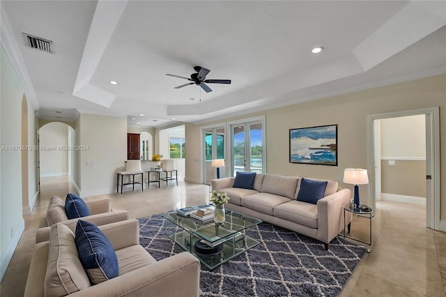 living room with crown molding, ceiling fan, and a raised ceiling