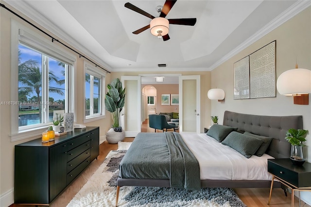 bedroom featuring ornamental molding, light hardwood / wood-style floors, and ceiling fan