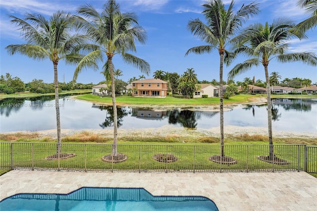 view of swimming pool featuring a water view and a lawn