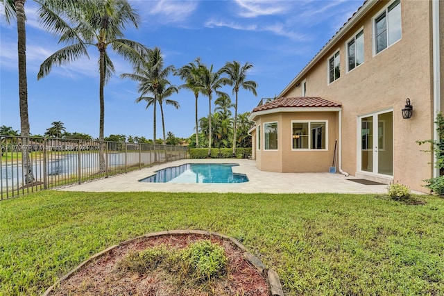 view of swimming pool featuring a patio, a lawn, and a water view