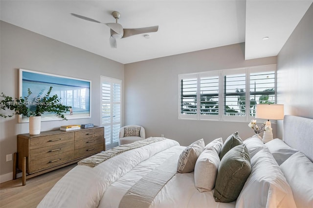 bedroom featuring light hardwood / wood-style floors, multiple windows, and ceiling fan