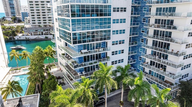 view of building exterior with a water view and a community pool