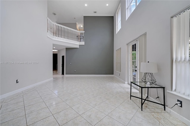 unfurnished living room with a healthy amount of sunlight and a towering ceiling