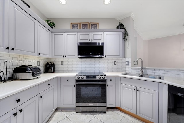 kitchen with decorative backsplash, ornamental molding, sink, light tile patterned flooring, and appliances with stainless steel finishes