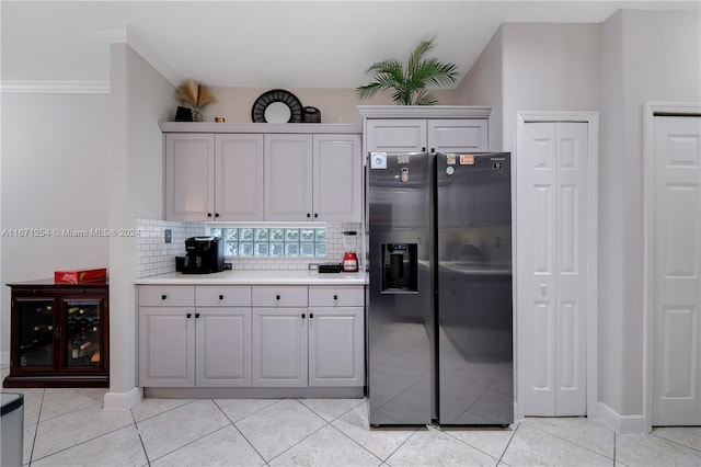 kitchen featuring ornamental molding, light tile patterned floors, backsplash, and stainless steel fridge with ice dispenser