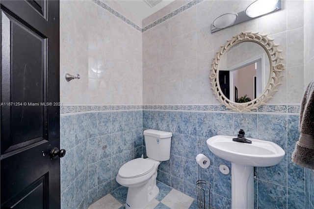 bathroom with tile walls and toilet