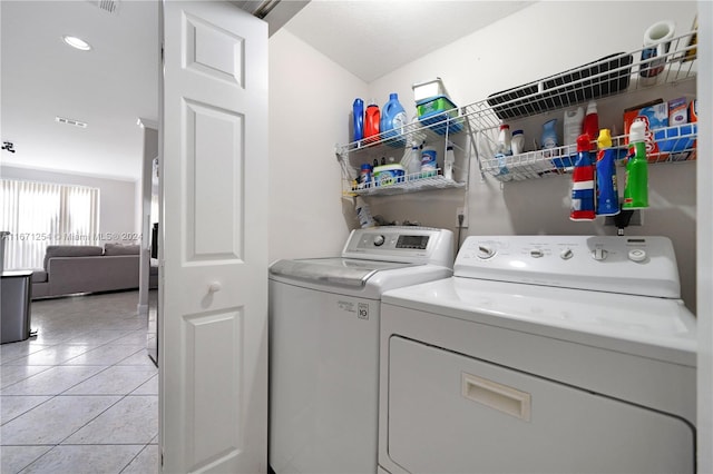 clothes washing area with independent washer and dryer and light tile patterned floors