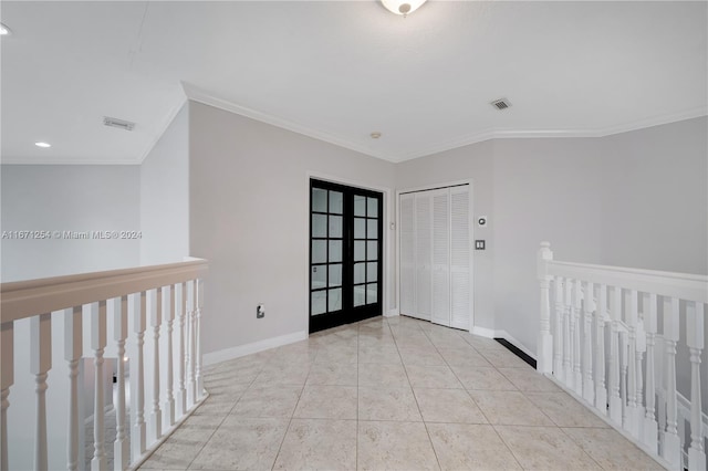 tiled empty room featuring french doors and crown molding