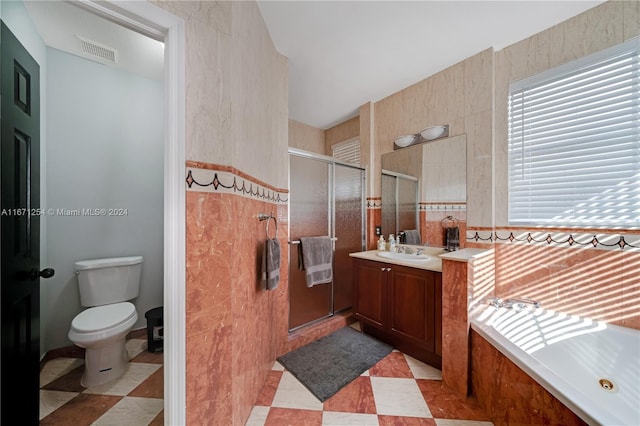 full bathroom featuring toilet, vanity, and independent shower and bath