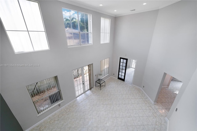 living room with french doors, ornamental molding, a healthy amount of sunlight, and a high ceiling