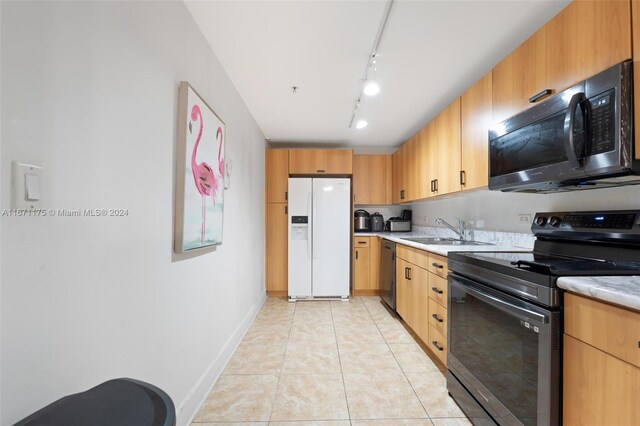 kitchen featuring appliances with stainless steel finishes, rail lighting, light tile patterned flooring, and sink