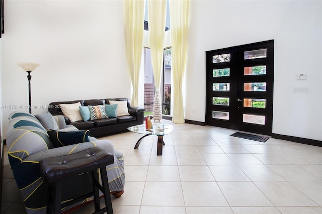 tiled living room featuring french doors and a high ceiling