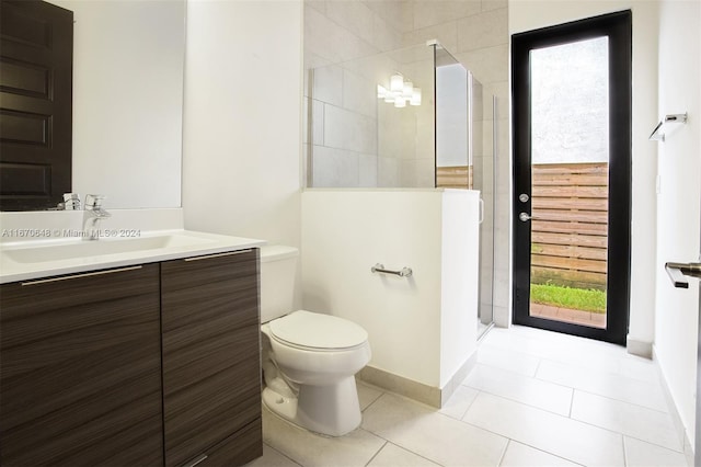 bathroom featuring vanity, toilet, tile patterned flooring, and a tile shower