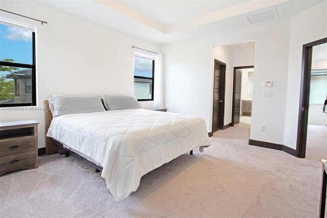 bedroom featuring light carpet and multiple windows