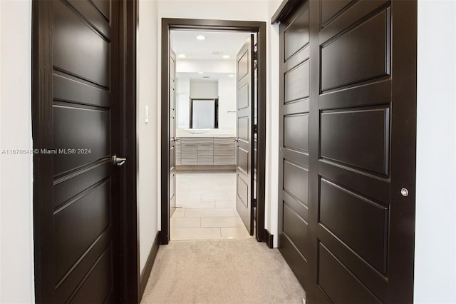 hallway featuring light colored carpet