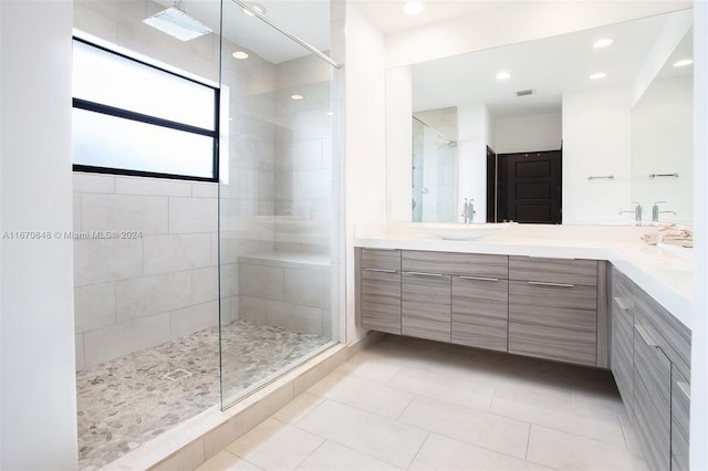 bathroom with tile patterned floors, vanity, and tiled shower