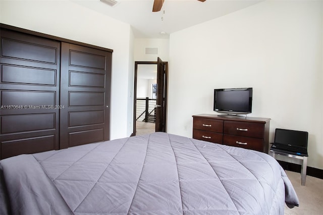 carpeted bedroom with ceiling fan and a closet