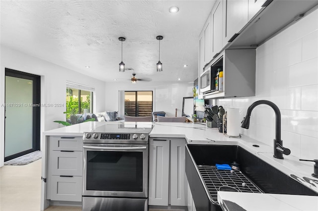 kitchen with appliances with stainless steel finishes, gray cabinetry, tasteful backsplash, a textured ceiling, and sink