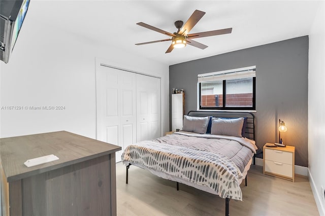 bedroom with light hardwood / wood-style floors, ceiling fan, and a closet