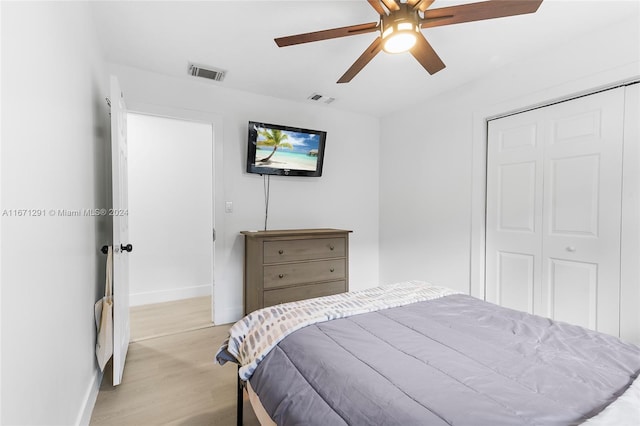 bedroom with ceiling fan, a closet, and light hardwood / wood-style floors