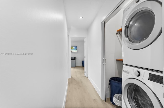 laundry area featuring light hardwood / wood-style floors and stacked washing maching and dryer