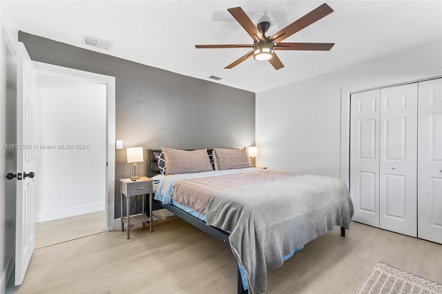 bedroom featuring a closet, light hardwood / wood-style floors, and ceiling fan