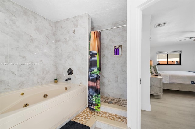 bathroom with ceiling fan, separate shower and tub, hardwood / wood-style floors, and a textured ceiling