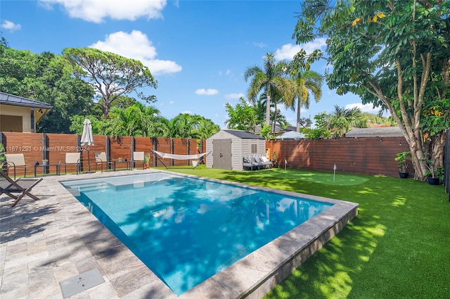 view of pool featuring a lawn, a storage unit, and a patio