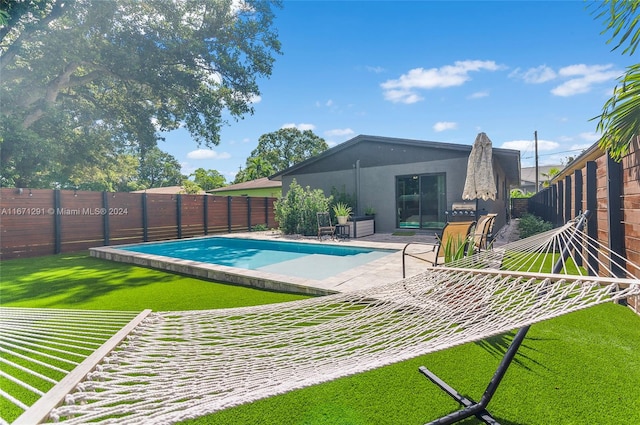 view of pool featuring a lawn and a patio