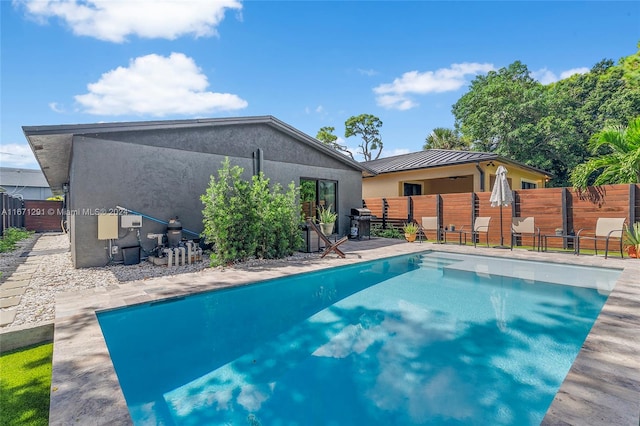 view of swimming pool featuring grilling area and a patio area