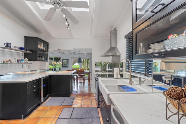 kitchen with pendant lighting, electric range, rail lighting, wall chimney exhaust hood, and light tile patterned floors