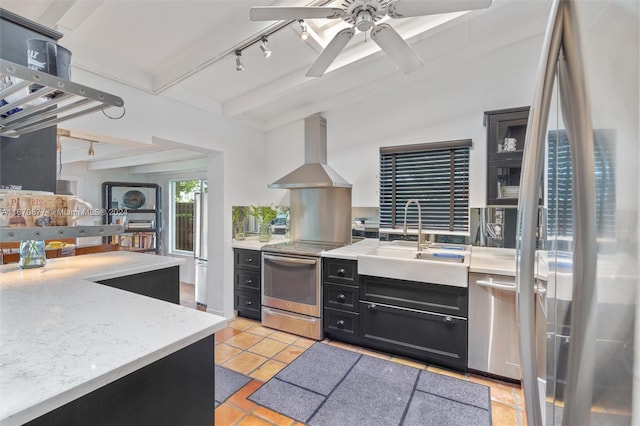 kitchen featuring beam ceiling, sink, wall chimney exhaust hood, track lighting, and appliances with stainless steel finishes