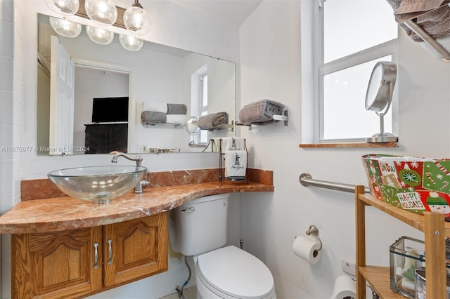 bathroom featuring vanity, toilet, and a wealth of natural light