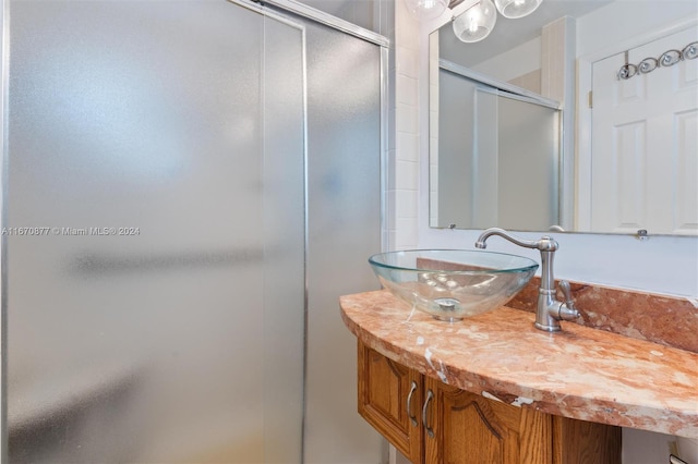 bathroom featuring vanity and a shower with door