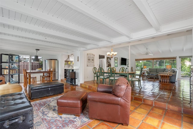 living room with ceiling fan with notable chandelier, vaulted ceiling with beams, and tile patterned flooring