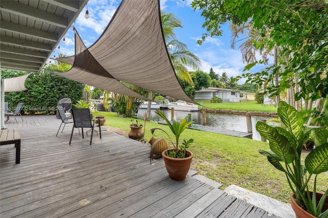 wooden deck featuring a lawn and a water view