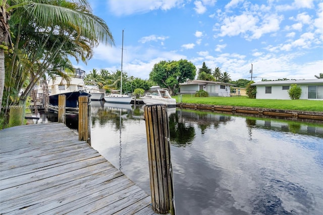 dock area featuring a lawn and a water view