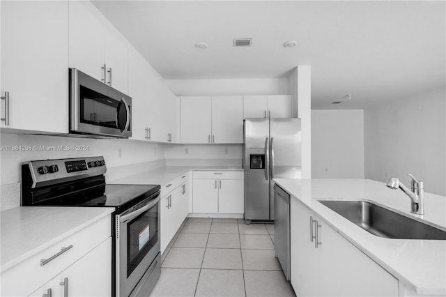 kitchen with light tile patterned flooring, sink, stainless steel appliances, and white cabinets