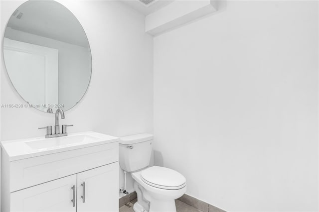 bathroom with vanity, toilet, and tile patterned floors