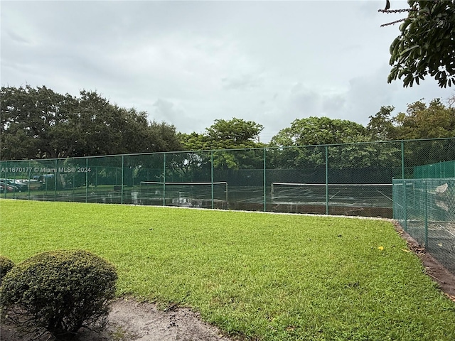 surrounding community featuring a yard and tennis court