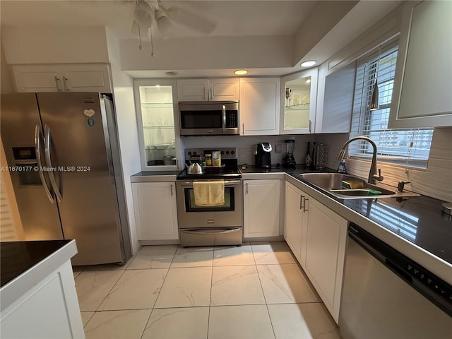 kitchen featuring ceiling fan, white cabinets, sink, tasteful backsplash, and appliances with stainless steel finishes