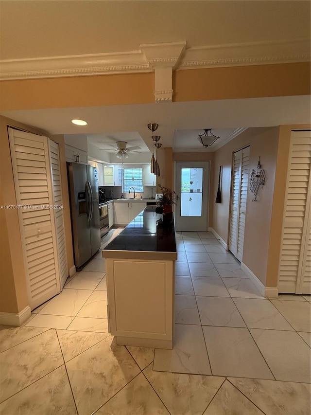 kitchen featuring ceiling fan, hanging light fixtures, sink, stainless steel fridge with ice dispenser, and crown molding