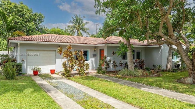 view of front of house with a garage and a front lawn